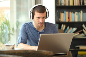 image of man sitting at computer transcription proofreading
