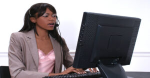 a young woman at a computer doing business transcription