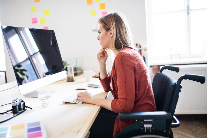 lady in a wheelchair looking at transcription samples on a desktop